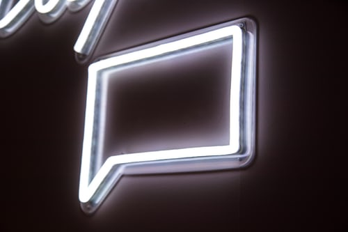 White glowing square message bubble mounted to a wall