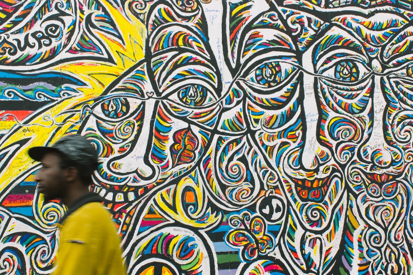 Man walking past a Wall of faces