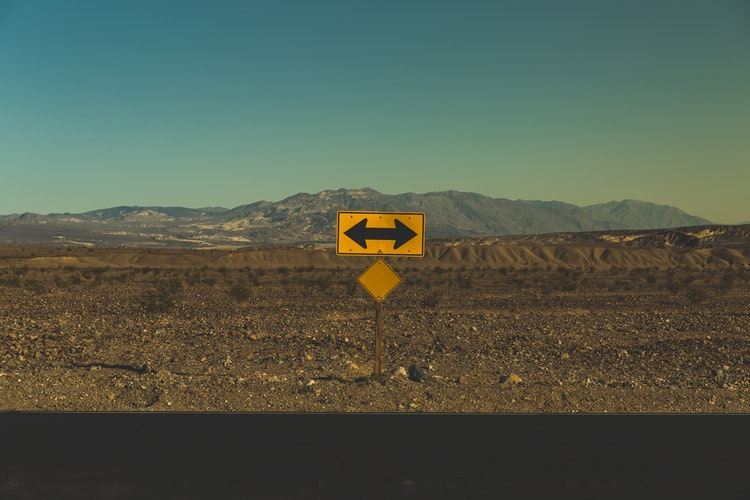 Road sign with arrow in two directions Road sign with arrow in two directions
