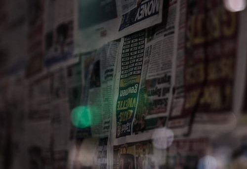 Newspapers taped to wall in dark room