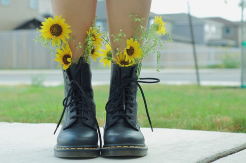 Person wearing boots with flowers sticking out