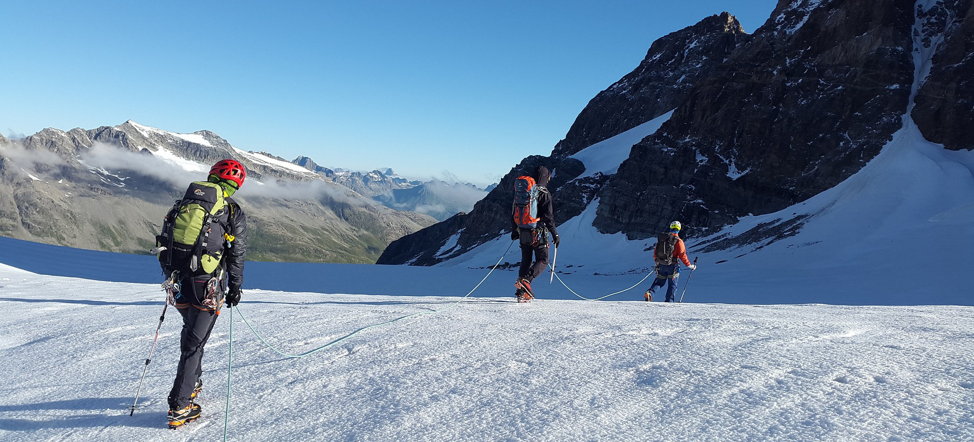 Team of hikers going up a snowy mountain