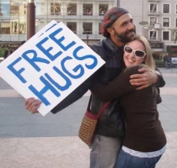 Free hugs sign and two people hugging