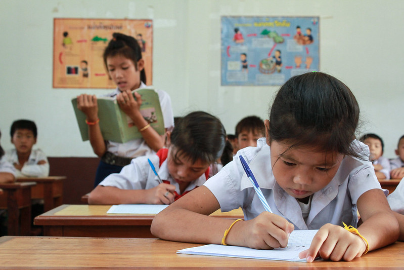 Children in classroom taking tests at their desks