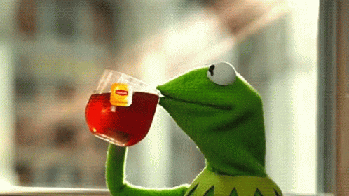 Kermit the frog holding up a glass of tea, as if to say "cheers!"